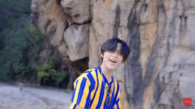 a young man wearing a blue and yellow striped shirt