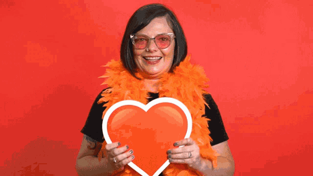 a woman holding a red heart in front of a red background that says love