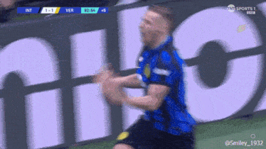 a soccer player is celebrating a goal in front of a large sign that says sports 1