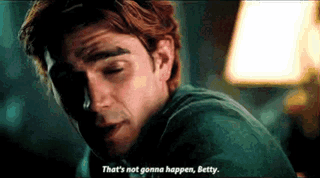 a man is sitting in a dark room with his eyes closed and talking to a woman .