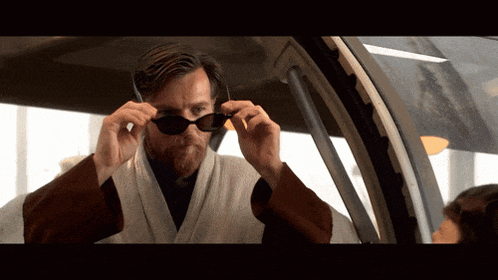 a man with a beard wearing sunglasses in a car