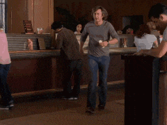 a man is dancing in a room with a woman in a pink shirt .