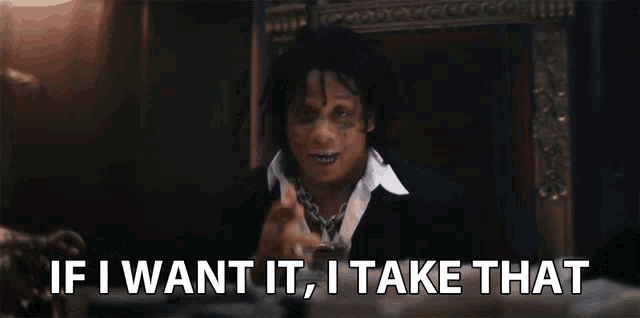 a man in a suit is sitting in a chair and says if i want it , i take that