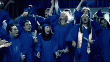 a group of graduates in blue gowns are cheering and holding their hats in the air