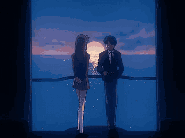 a man and a woman standing on a balcony overlooking the ocean at sunset