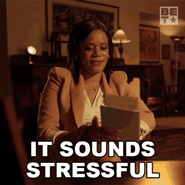a woman sitting at a table holding a piece of paper and the words it sounds stressful