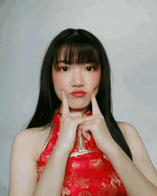 a woman in a red dress with hearts on her head makes a funny face
