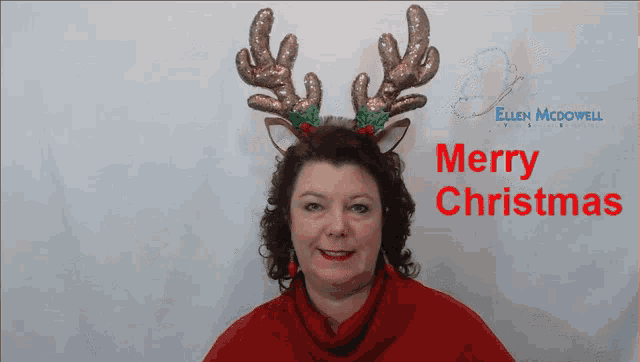 a woman wearing a reindeer headband with the words merry christmas behind her