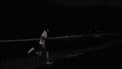 a person running on a beach at night