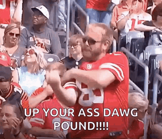 a man in a san francisco 49ers jersey is dancing in a crowd of people at a football game .