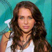miley cyrus is wearing a white tank top and earrings