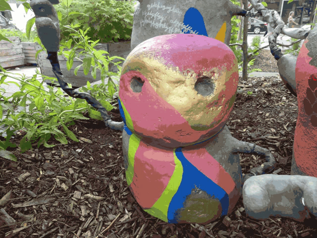 a statue with a face painted on it is sitting in the ground