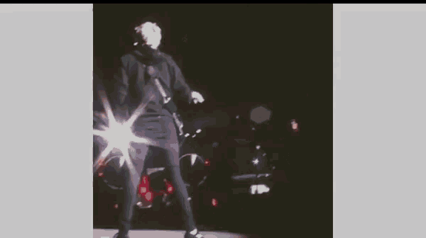 a man is standing on a stage holding a microphone and dancing .