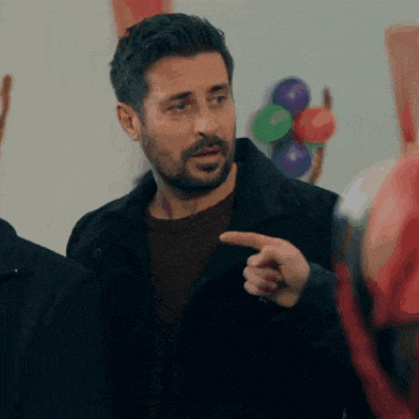 a man with a beard is pointing his finger at someone