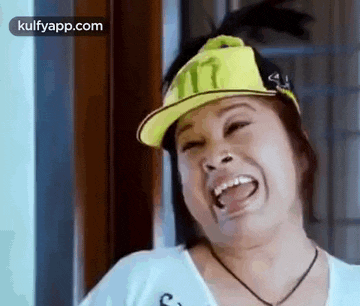 a woman wearing a yellow hat and a white shirt is laughing .