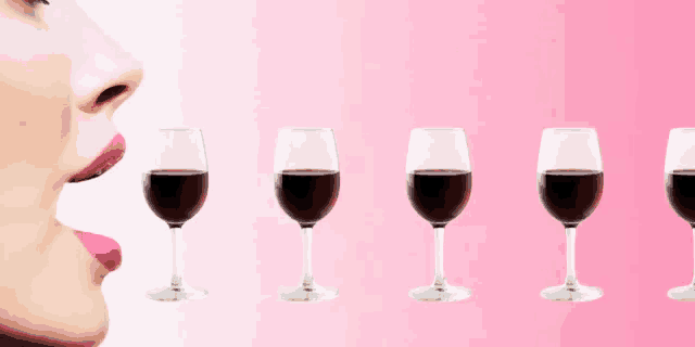 a woman licks her lips next to a row of glasses of wine