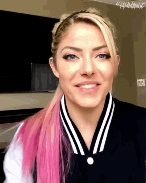 a woman with pink hair is wearing a black and white striped jacket