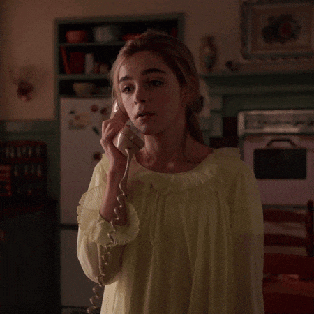 a woman in a yellow dress talks on a telephone