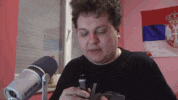 a man smoking a cigarette in front of a microphone