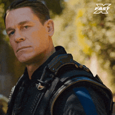 a close up of a man 's face with a fast x logo in the background
