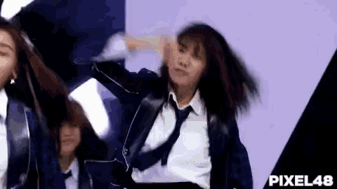 a woman in a suit and tie is dancing on stage .
