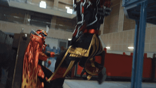 a man in a red and black costume is fighting another man in a black and gold costume
