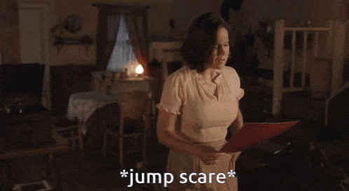 a woman holding a piece of paper that says jump scare on it