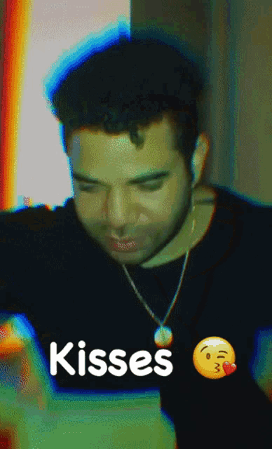a man wearing a necklace and a kisses emoji