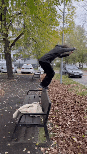 a person is jumping over a bench with a blanket on it