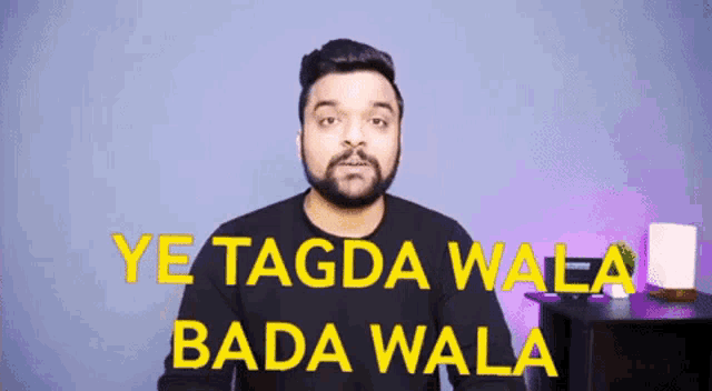 a man with a beard says ye tagda wala bada wala in yellow letters