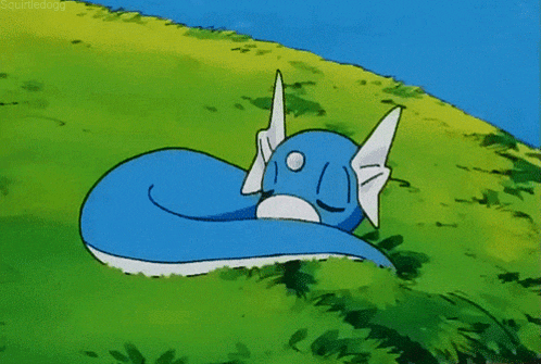 a blue and white cartoon character is laying in the grass ..