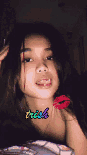 a girl with trish written on her neck is taking a selfie