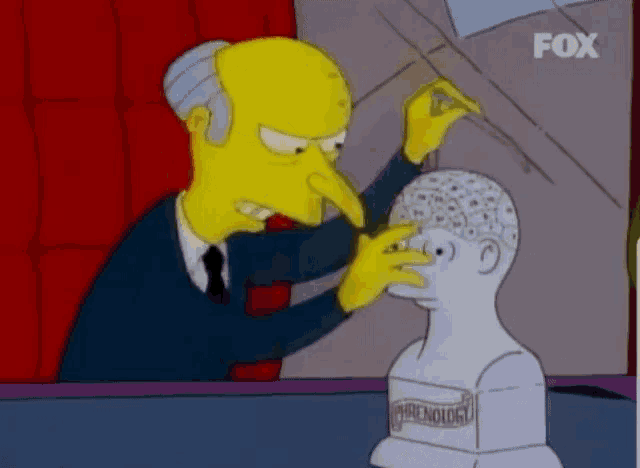 a cartoon character is touching a statue of a man 's head that says phrenology