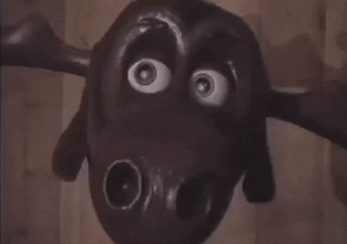 a close up of a moose statue with a wooden background