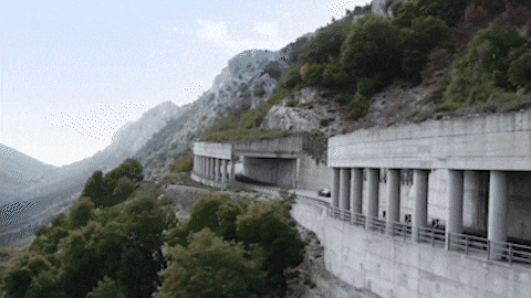 an aerial view of a highway going through a mountain valley .