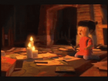 a little girl in a red shirt is sitting on the floor with candles in the background