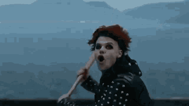a man with red hair is holding a hammer in his hand .