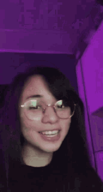 a close up of a woman wearing glasses and a black shirt