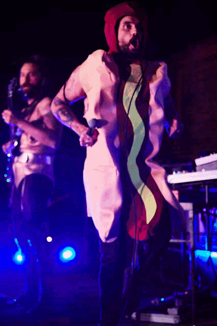 a man wearing a hot dog costume is singing into a microphone