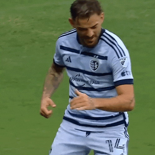 a soccer player wearing a compass minerals jersey celebrates on the field