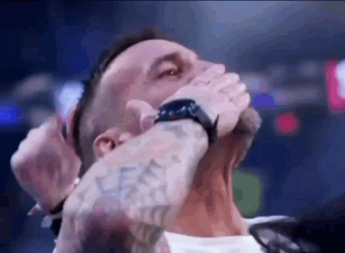 a man with a watch on his wrist is covering his mouth