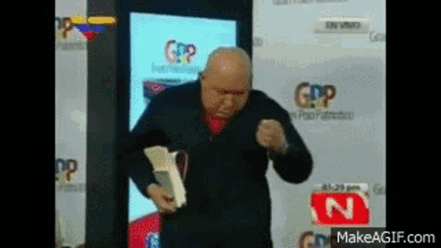 a man is standing in front of a microphone and holding a book .