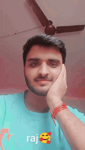 a man with a beard wearing a blue shirt that says raj