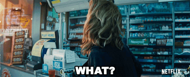 a woman standing in front of a cash register with the word what written on it