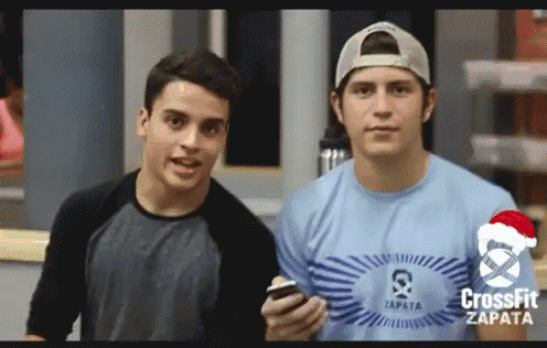 a man wearing a blue shirt that says crossfit zapata is standing next to another man