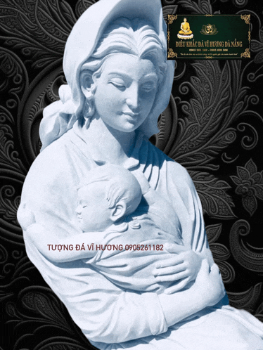 a statue of a woman holding a baby with a sign above it that says tương da vi huong