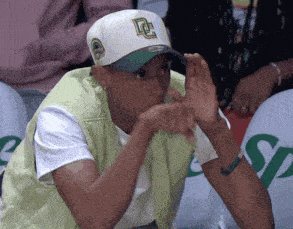 a man wearing a white hat with a green letter l on it