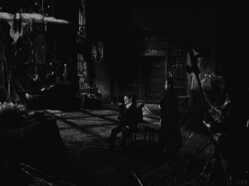 a black and white photo of a bat flying over a man playing a piano