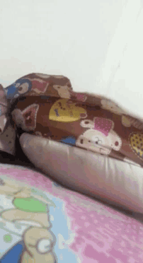 a bed with a pillow and a blanket with a cartoon character on it