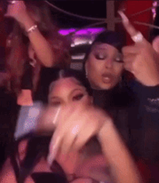 a blurry picture of a group of women dancing in a club .